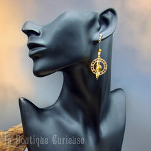 Laden Sie das Bild in den Galerie-Viewer, Boucles d'oreilles originales style steampunk inspirées des astrolabes anciens instruments de navigation. Boucles d'oreilles légères verre soufflé oeil de tigre et aventurine. Bijoux steampunk Toulouse France