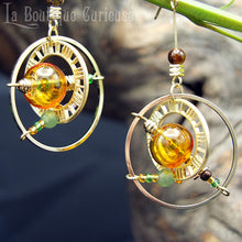 Charger l&#39;image dans la galerie, Boucles d&#39;oreilles style steampunk inspirées des astrolabes anciens instruments de navigation. Boucles d&#39;oreilles légères verre soufflé oeil de tigre et aventurine. Bijoux steampunk Toulouse France