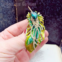 Laden Sie das Bild in den Galerie-Viewer, broche style retro plume de paon verte et dorée, inspiration art nouveau fantaisie tenue en main